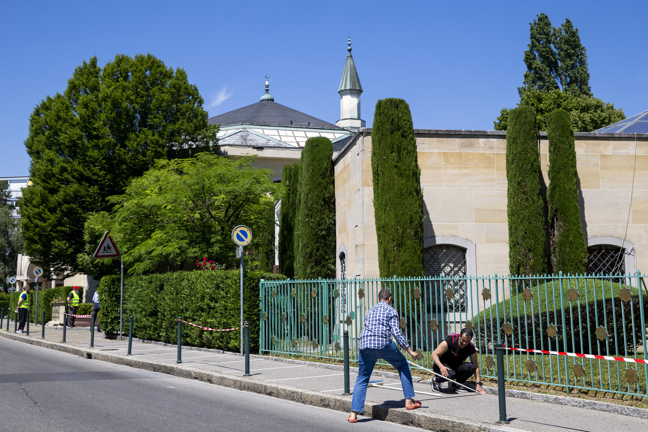 Dos hombres trabajan al exterior de una mezquita.