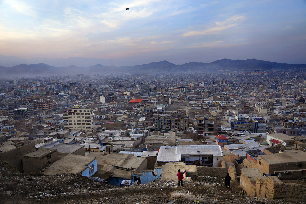 la ciudad de kabul y un niño jugando con una cometa
