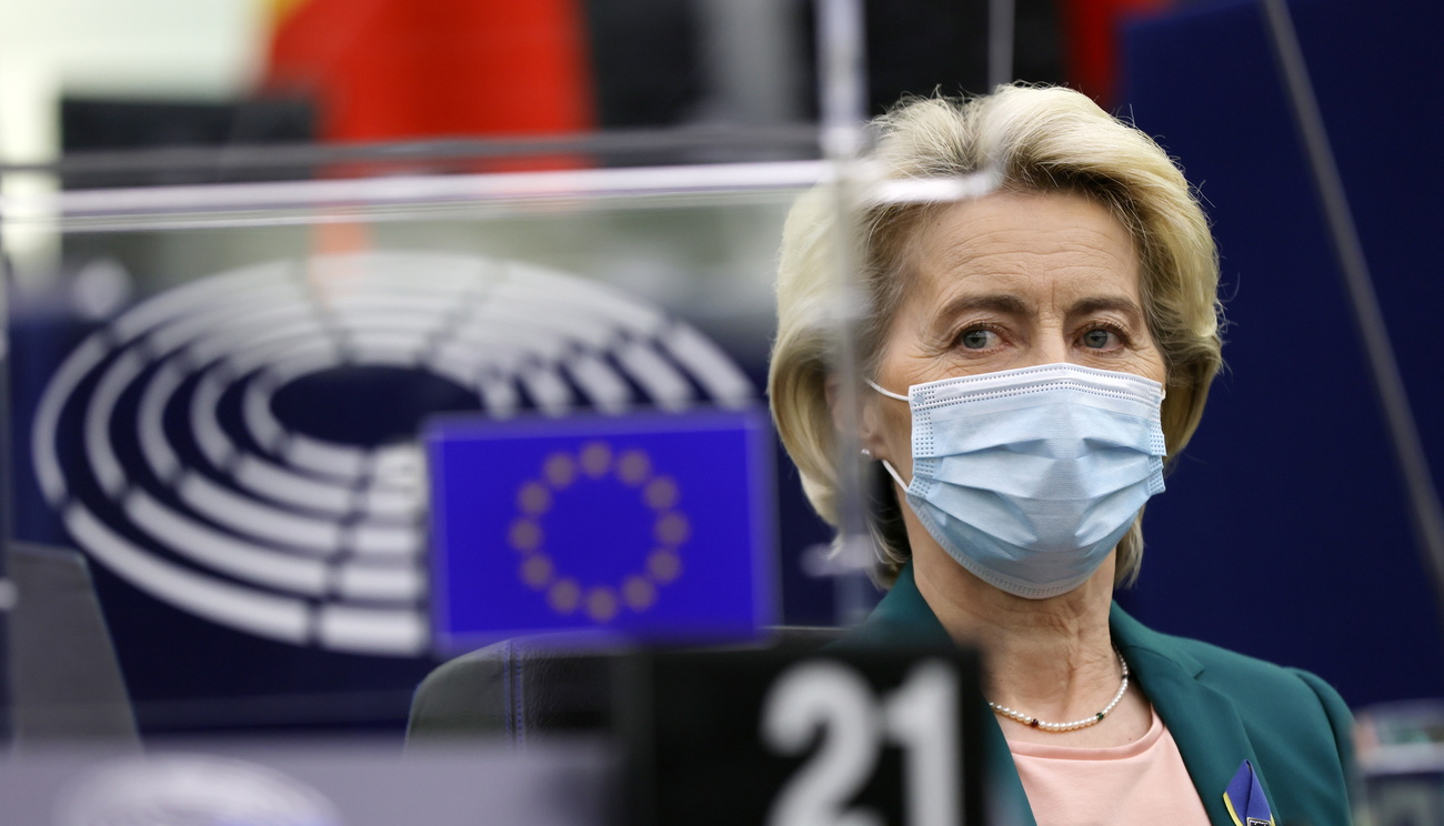 donna bionda con mascherina e giacca blazer verde