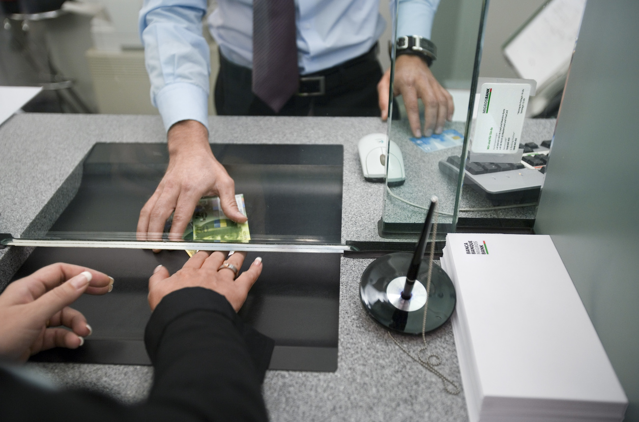 Person hands over bank notes at a bank counter