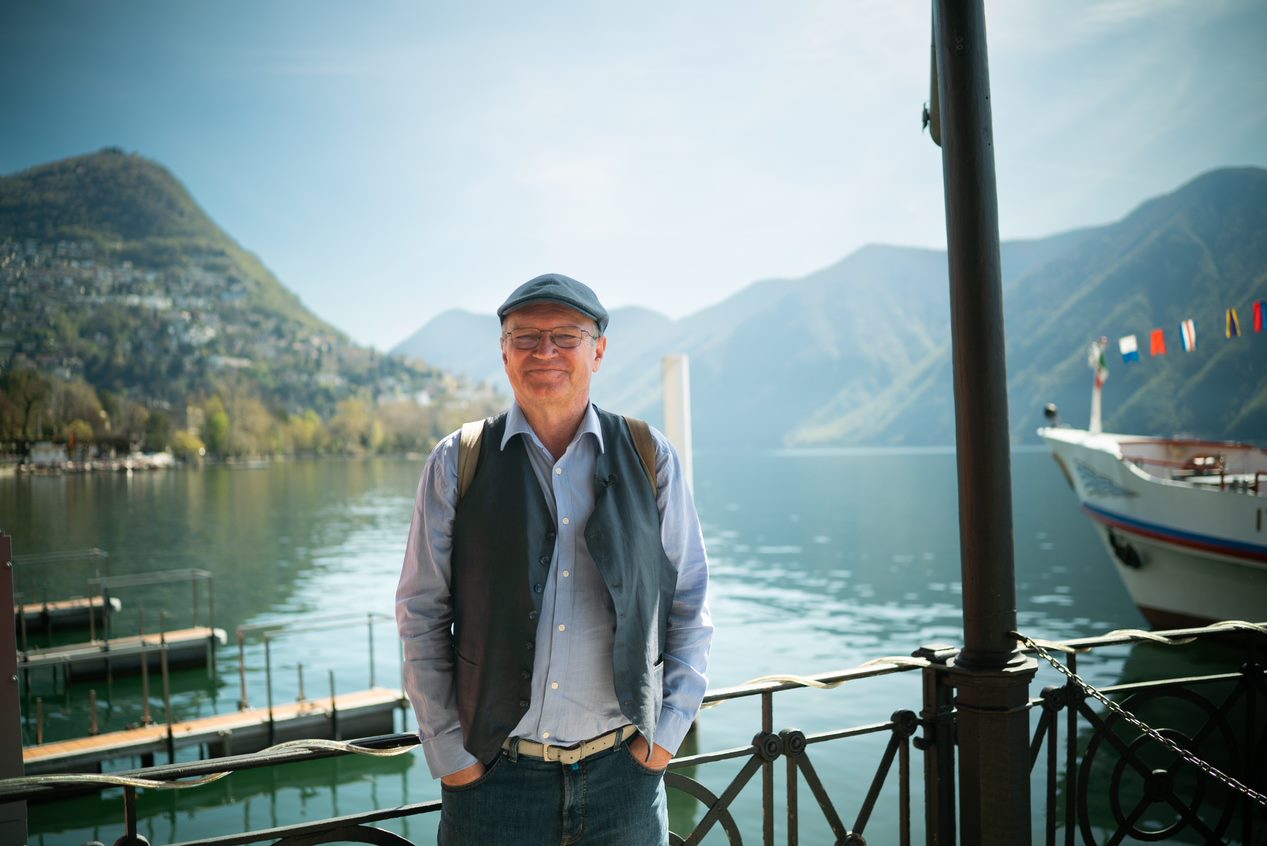 Homme avec une casquette devant le lac de Lugano