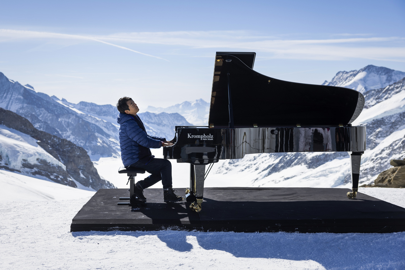 man plays piano on snowy mountaintop