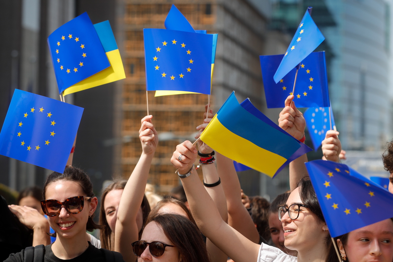 Demonstrierende schwenken EU- und Ukraine-Fähnchen.