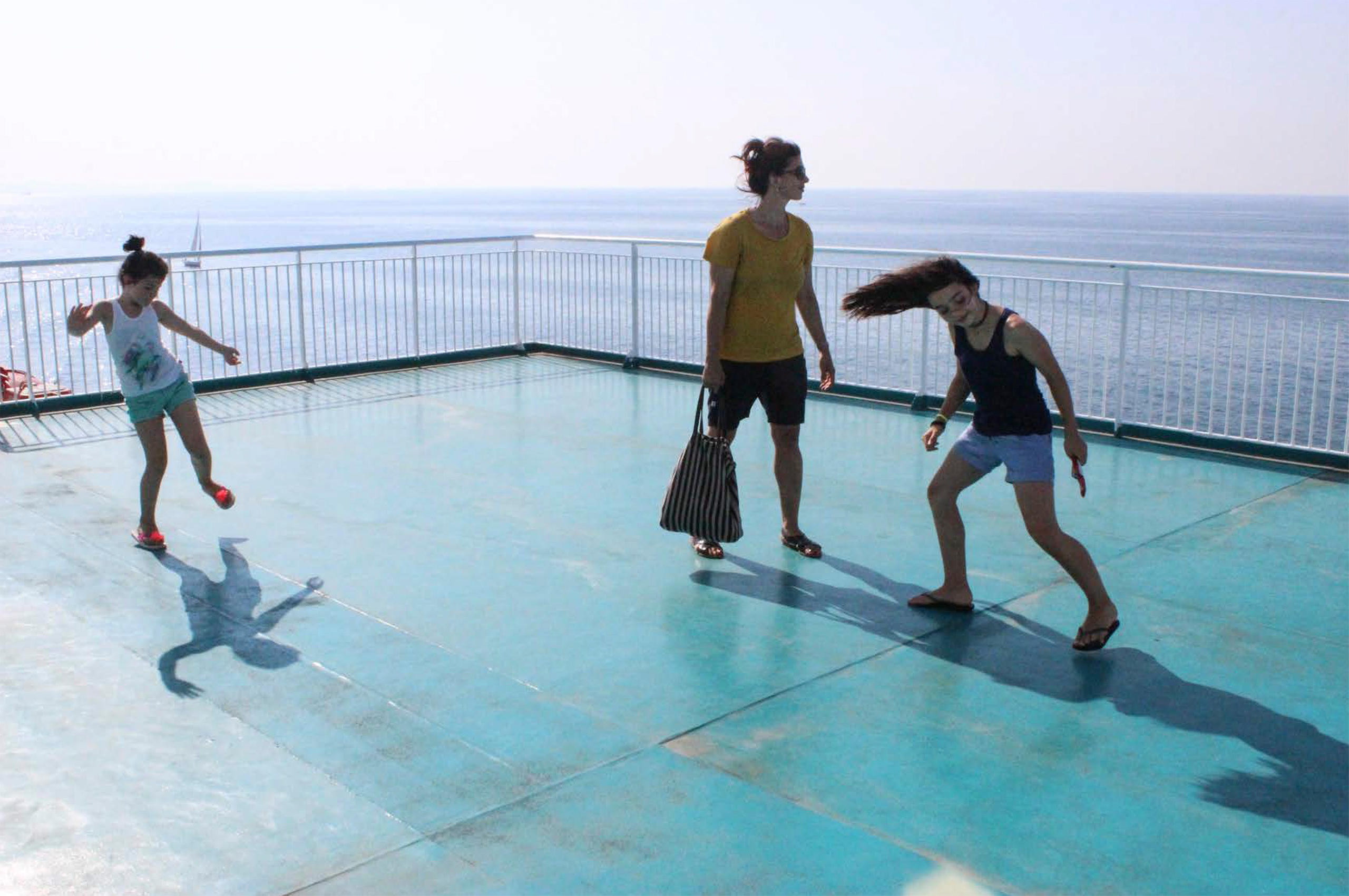 due bambine e una donna sul ponte di una nave