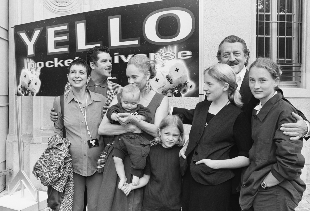 Zwei Familien posieren vor einem Yello -Transparent