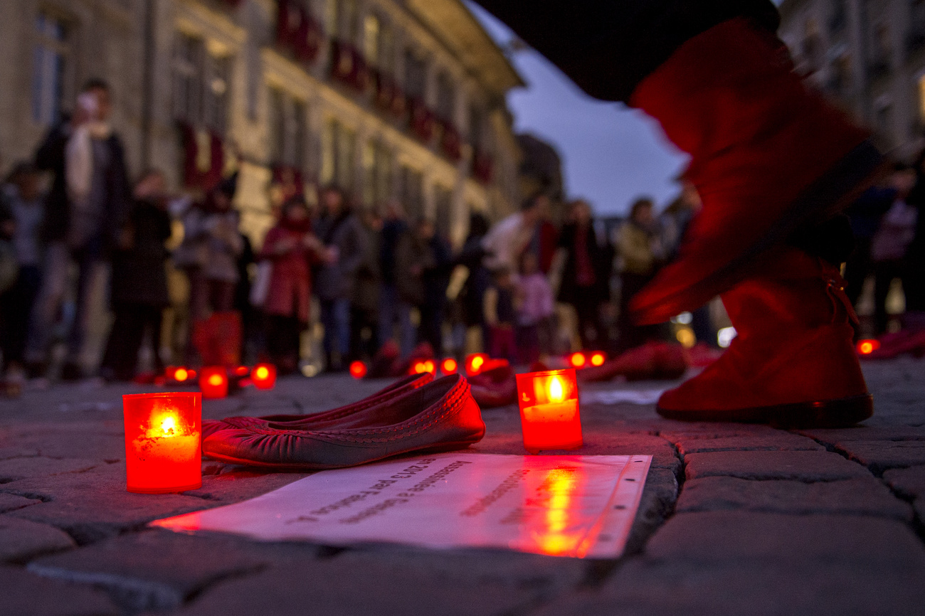 Candele accese con delle scarpe da donne per denunciare le violenze sulle donne.