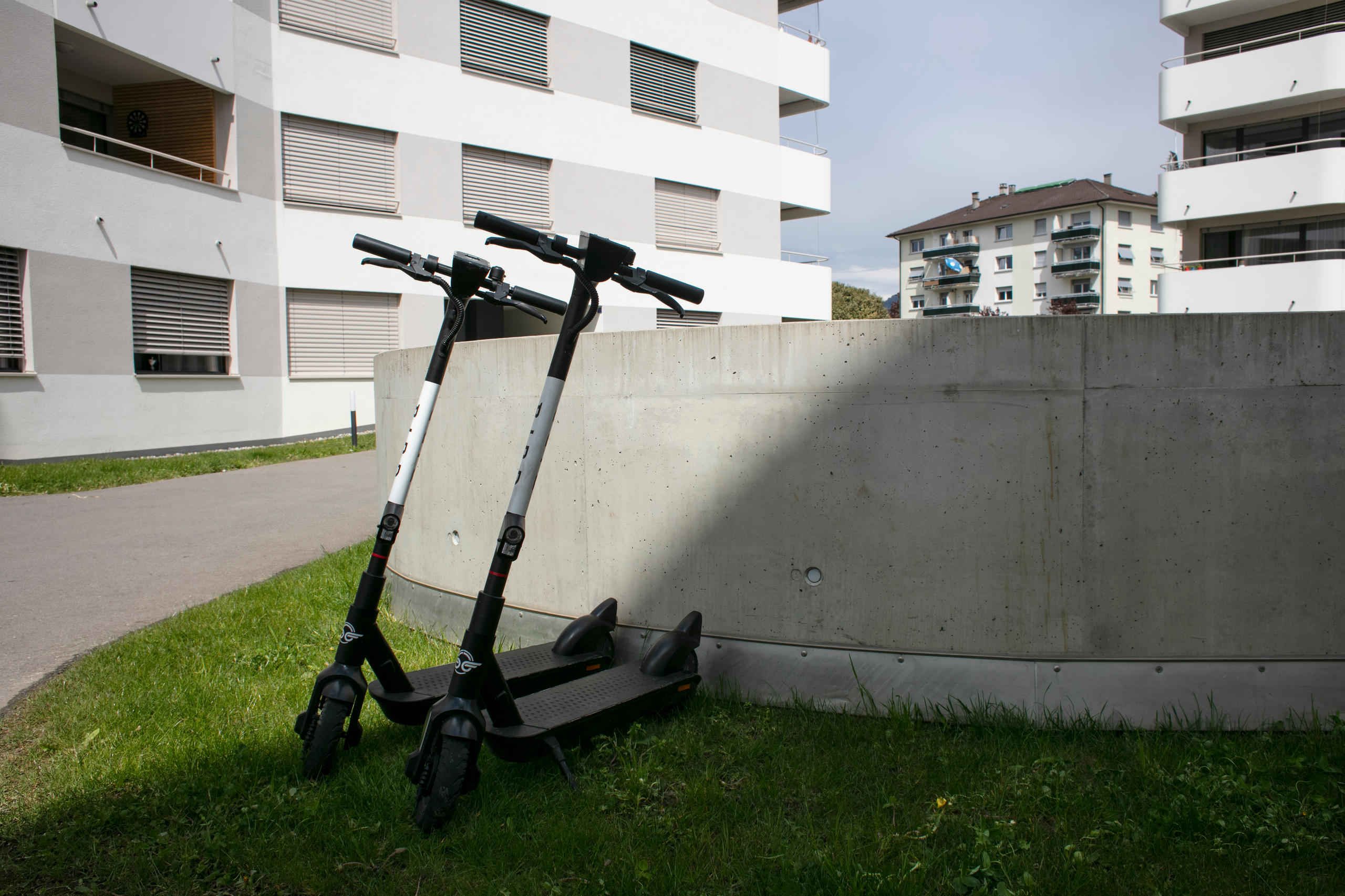 新住宅區的大院內停著兩輛出租電動滑板車，將人們與現代生活緊密地“連接”在一起。