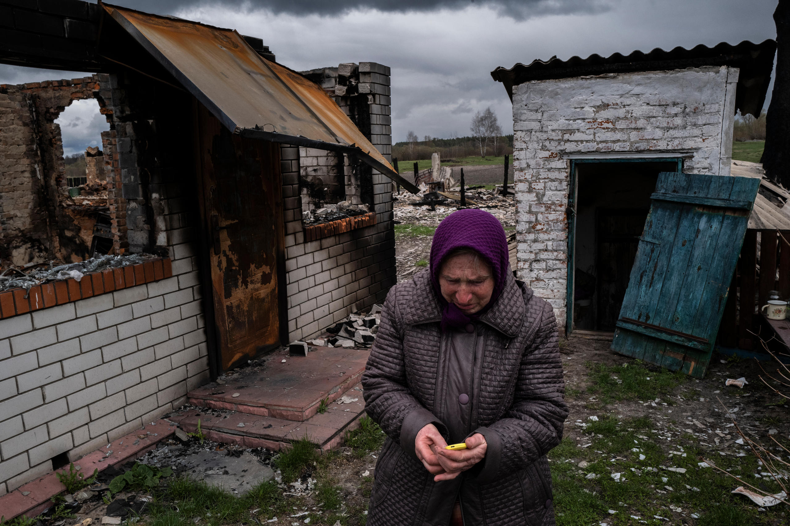 mujer mayor llorando en un pueblo en ruinas