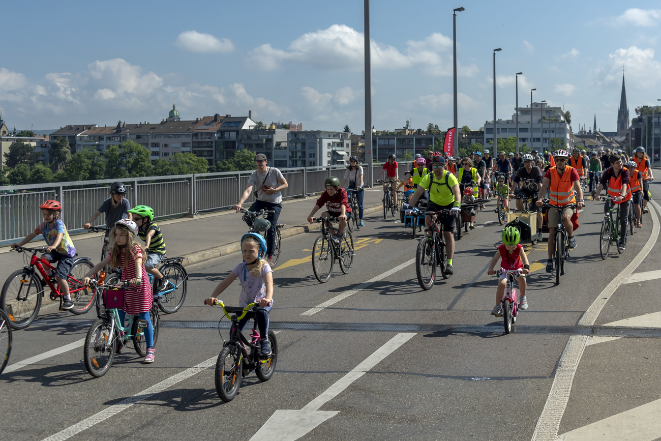 Crianças e adultos pedalando sobre uma ponte durante um protesto de bicicleta