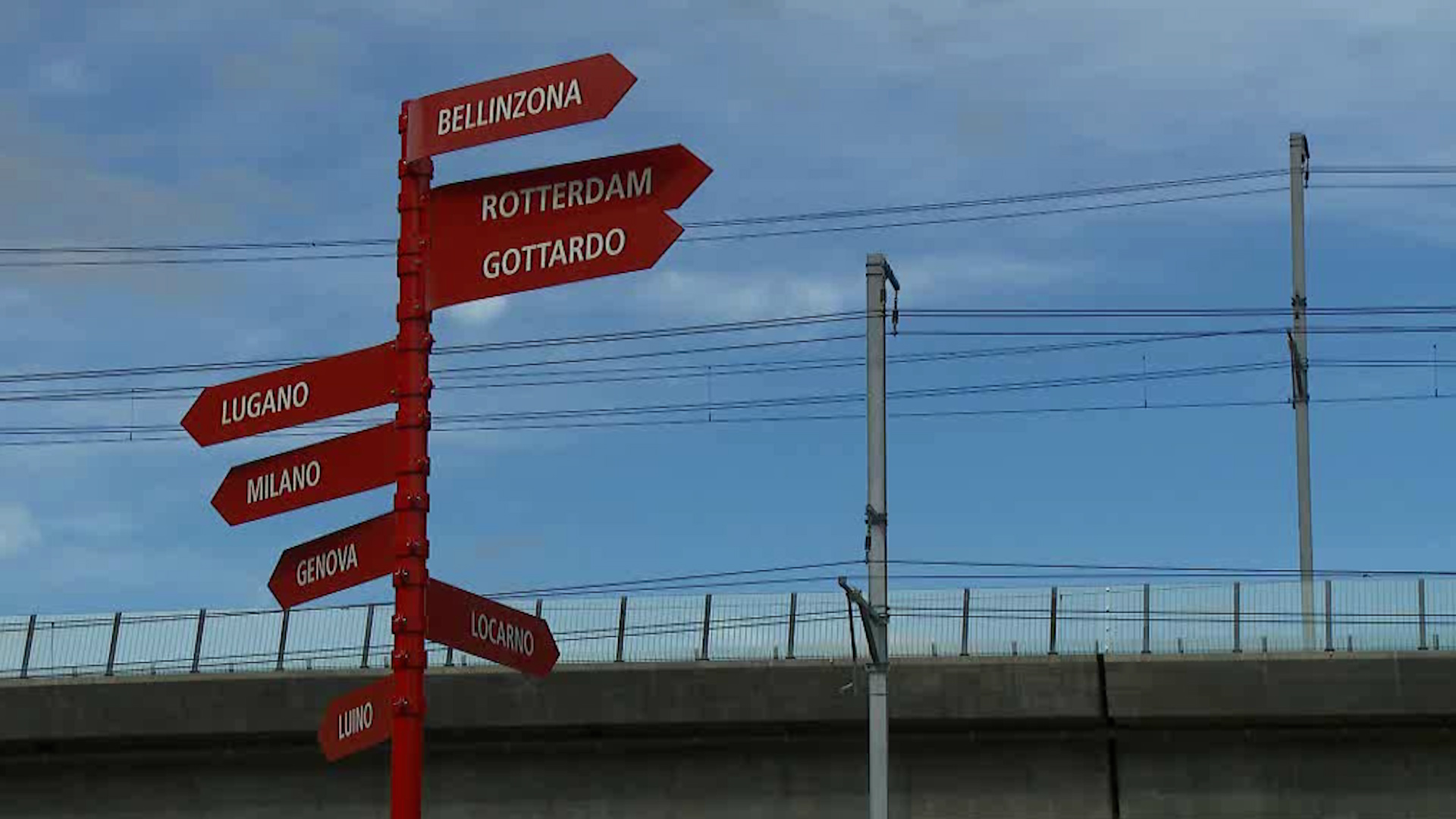 Segnali stradali indicanti le diverse località da Rotterdam a nord a Genova a sud.