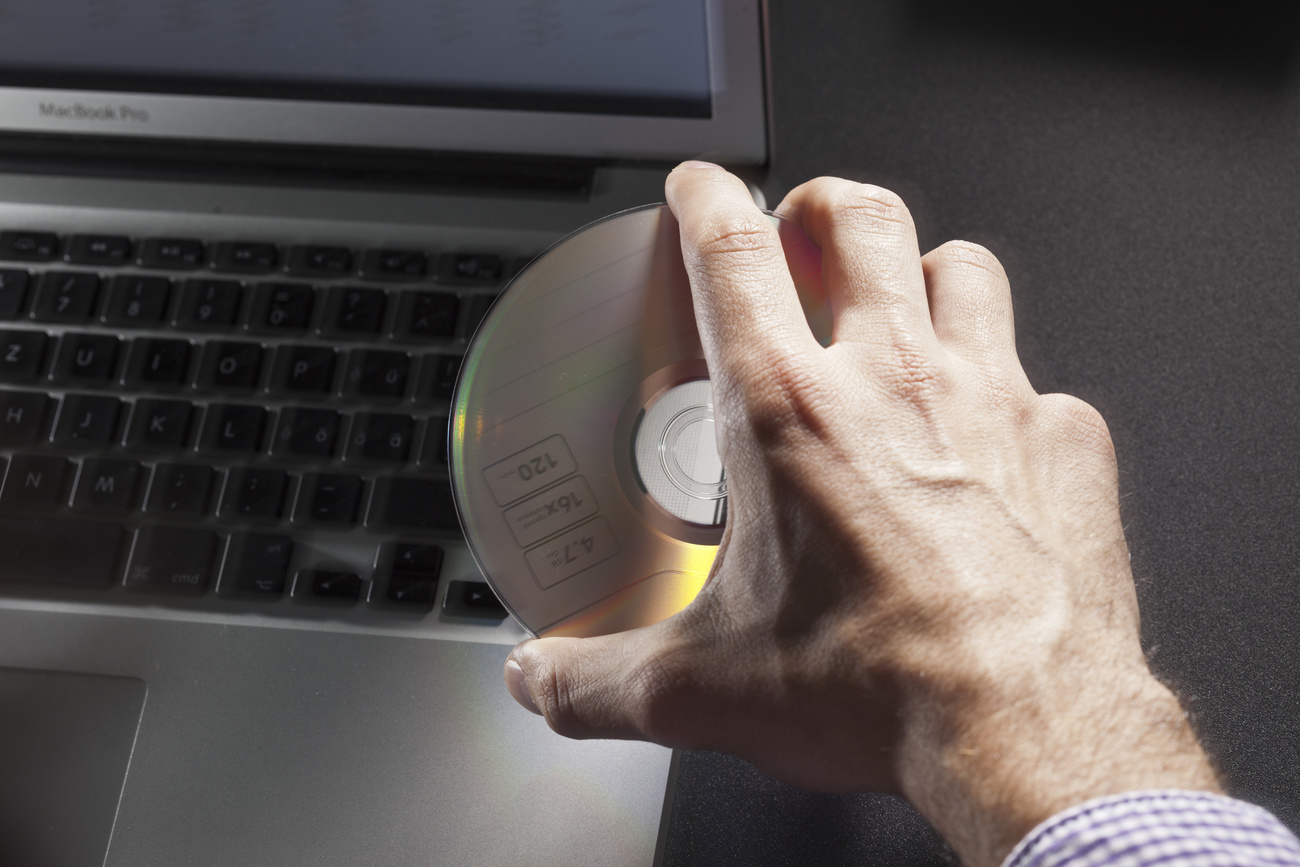 Hand removing disc from computer