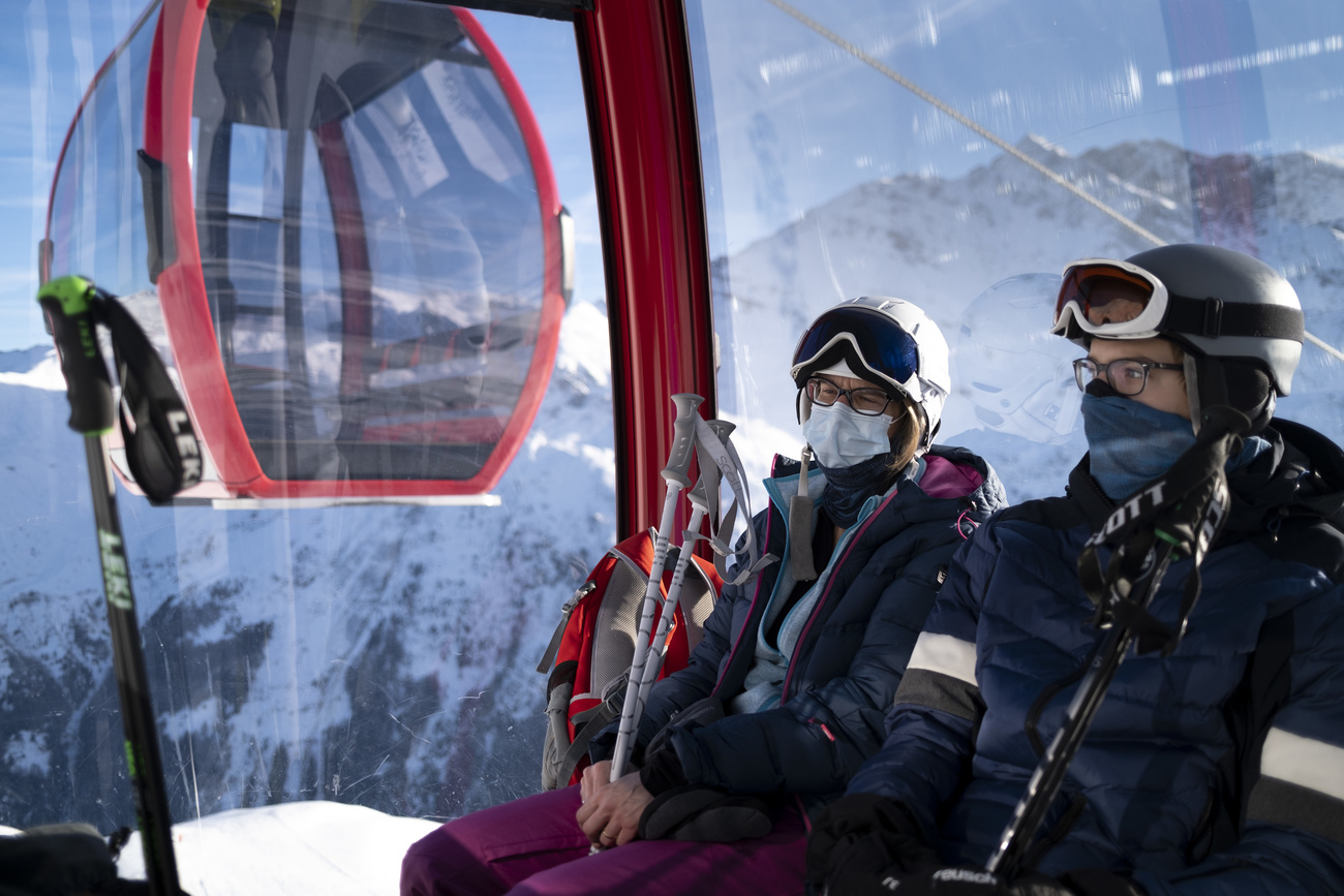 Esquiadores usando máscaras em uma gôndola