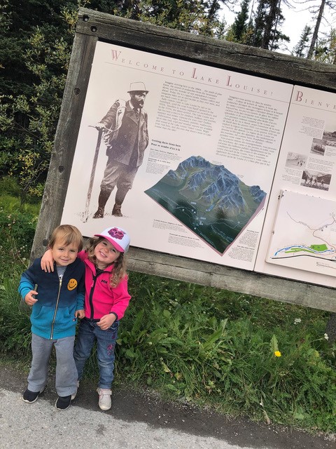Sohn und Nichte vor Willkommensschild.