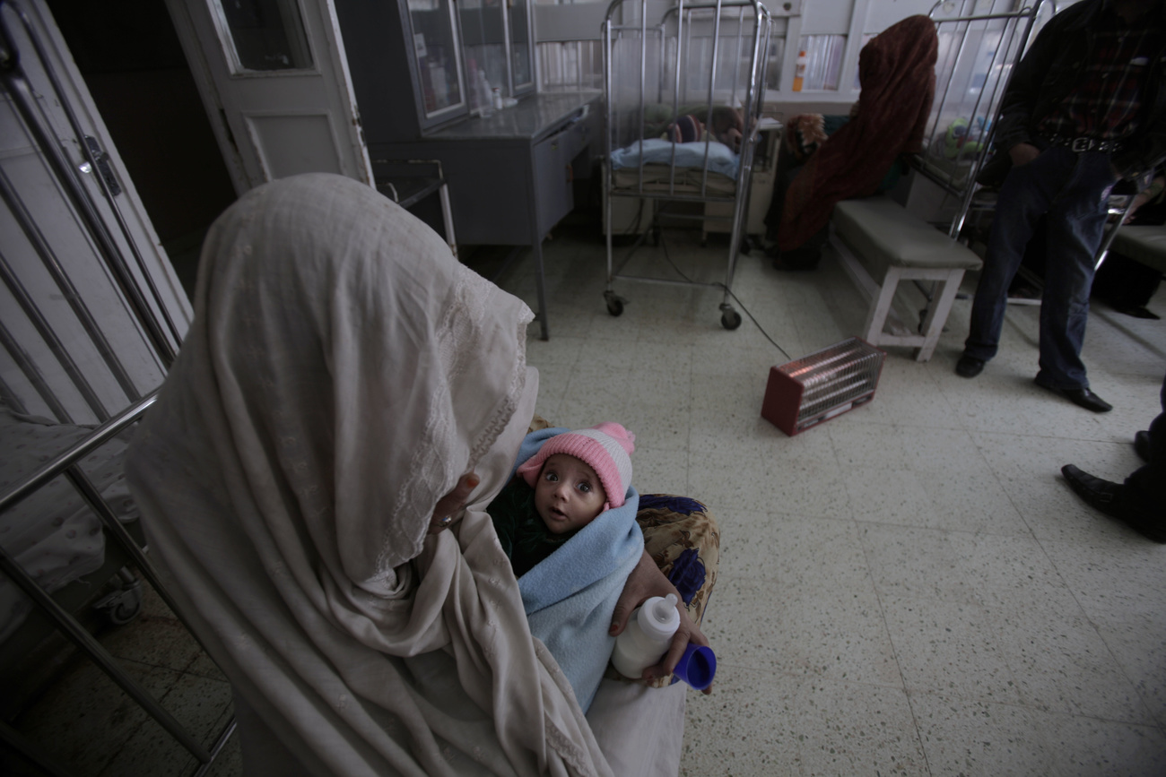 Woman with covered head holding baby