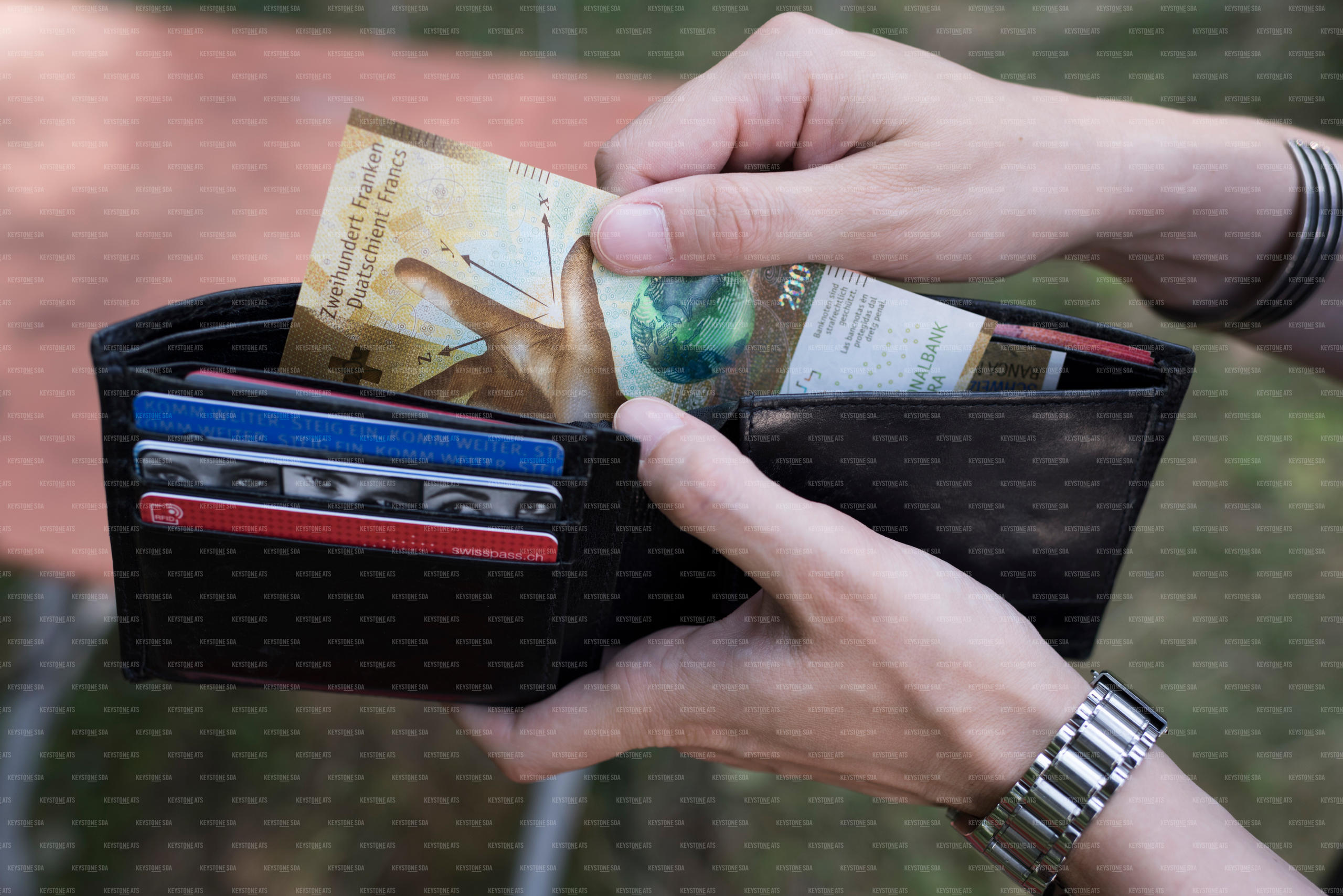 portafoglio dal quale viene estratta banconota da 200 franchi