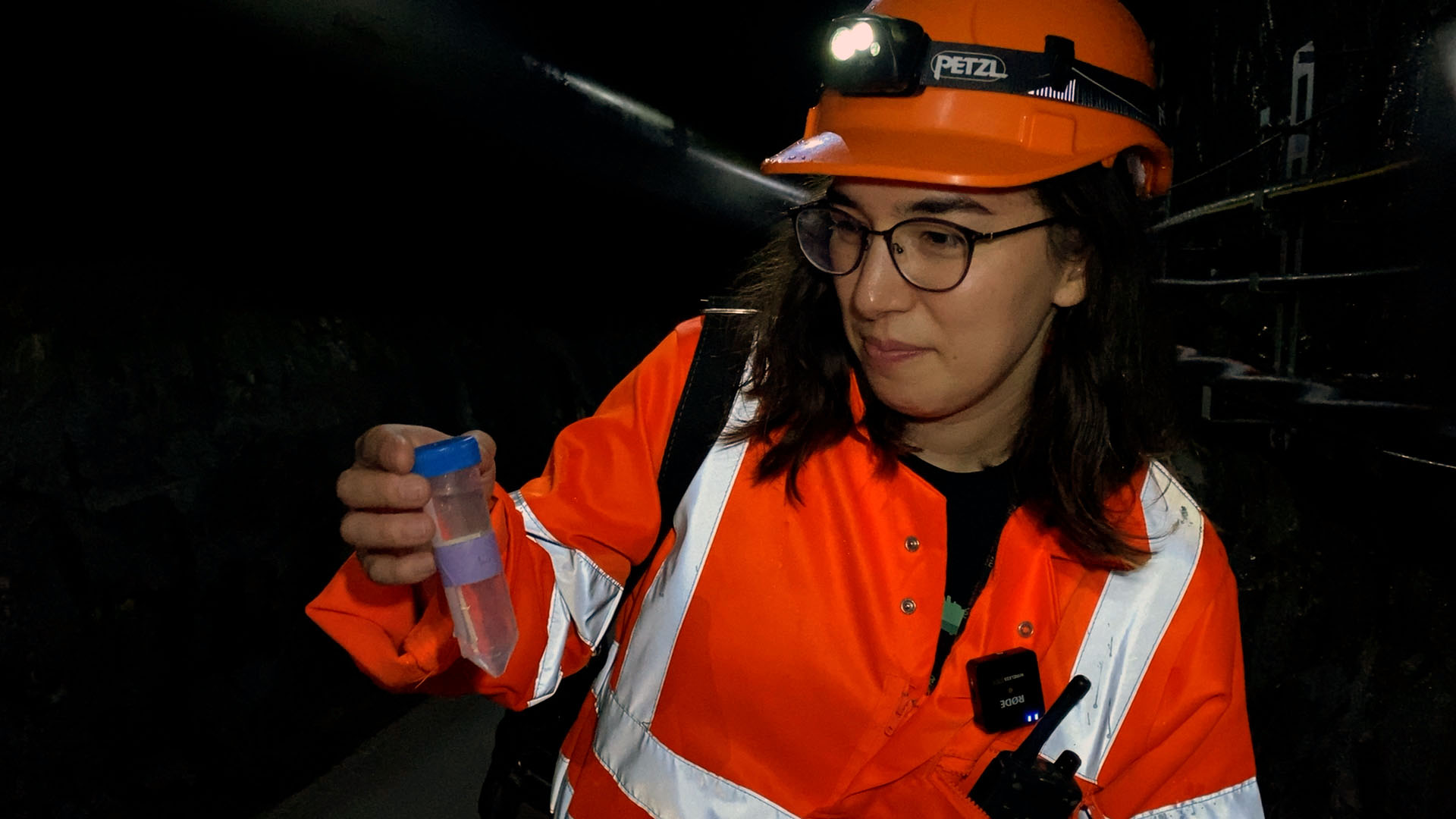 Femme avec un casque faisant des prélèvements à l intérieur d une montagne.