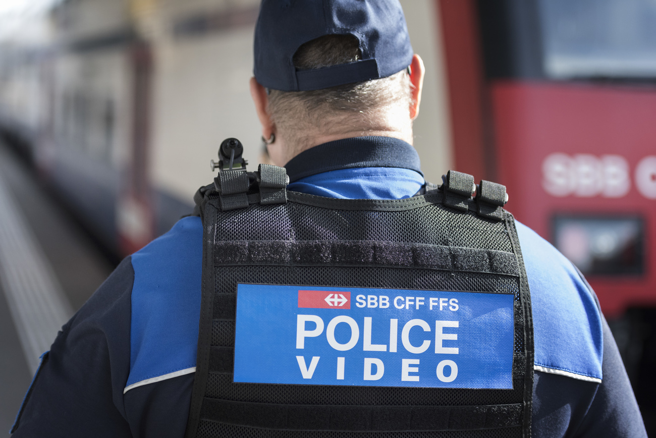 Policía de espaldas con una cámara de video en el hombro