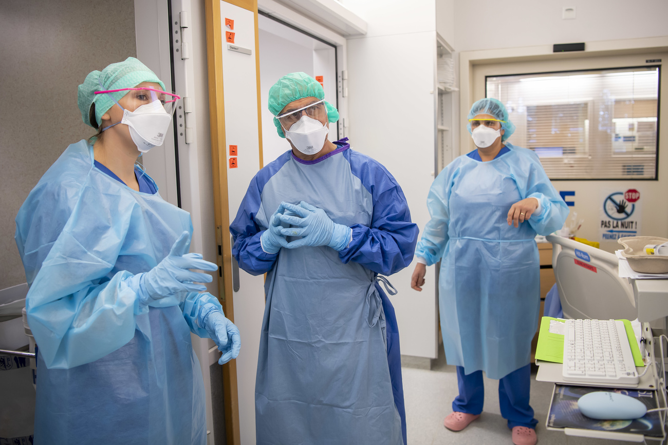 Tre persone con protezioni sanitarie in un ospedale.