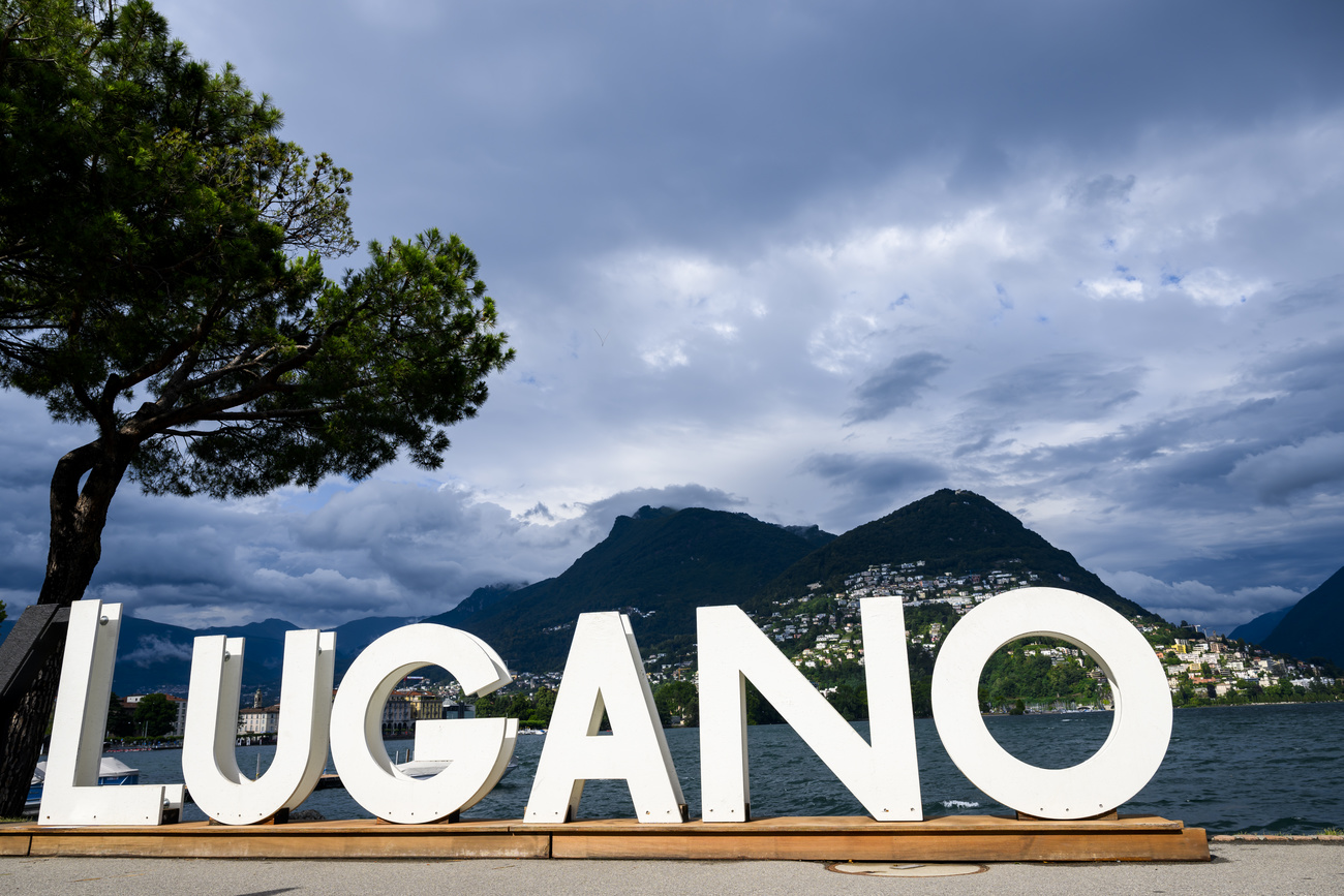 scritta LUGANO e sullo sfondo lago e montagna