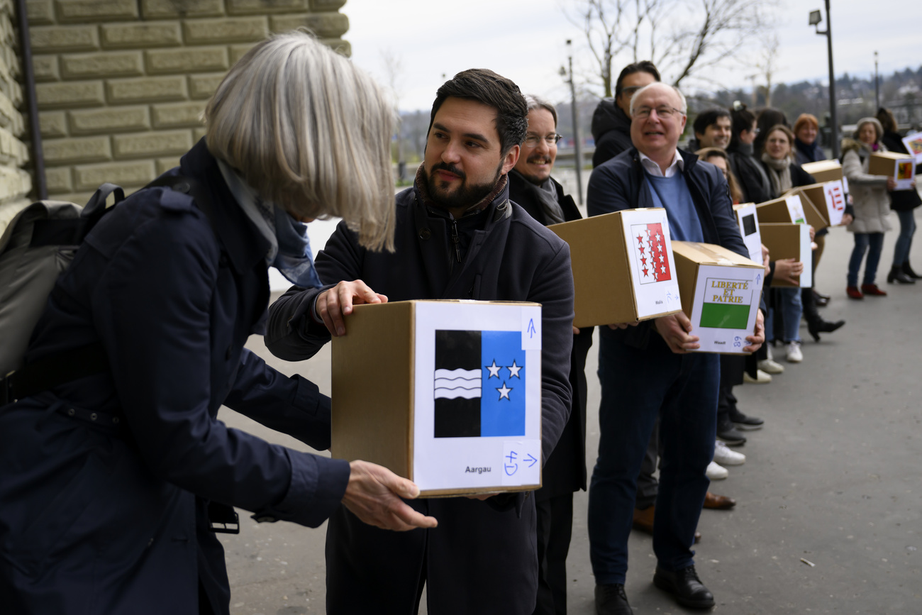 Fila de personas con cajas en los brazos.