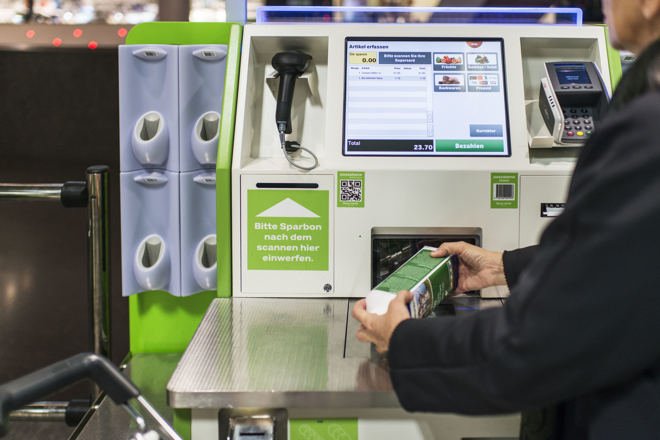 Una persona escanea un producto en un cajero automático de supermercado