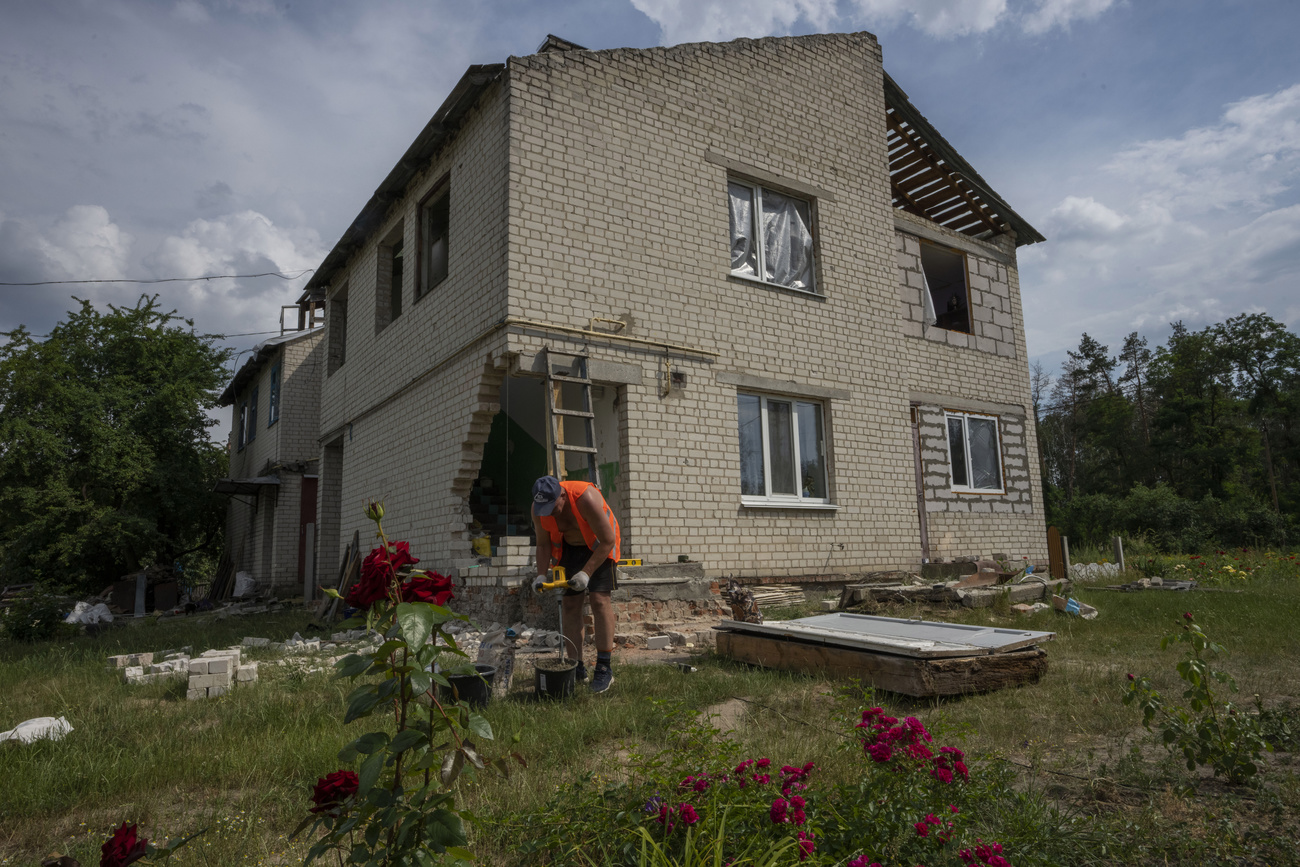 在烏克蘭切爾尼戈夫地區的亞希德內村，一名男子正在修理被俄軍炸毀的房屋。