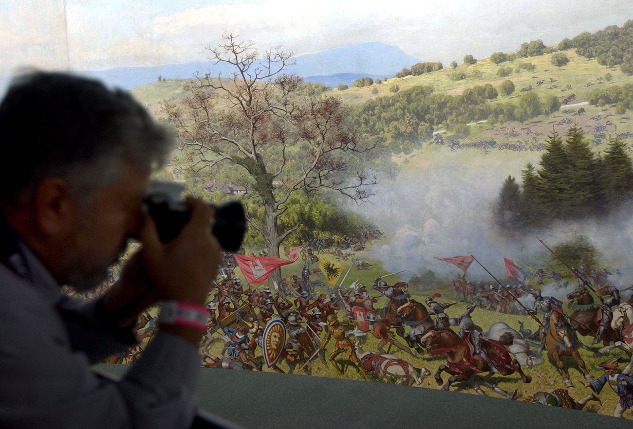 Homme en train de photographier une scène de bataille sur un tableau