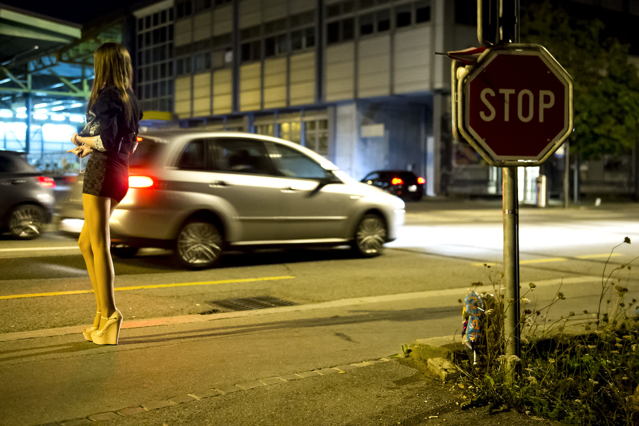 Una giovane prostituta a bordo di una strada.