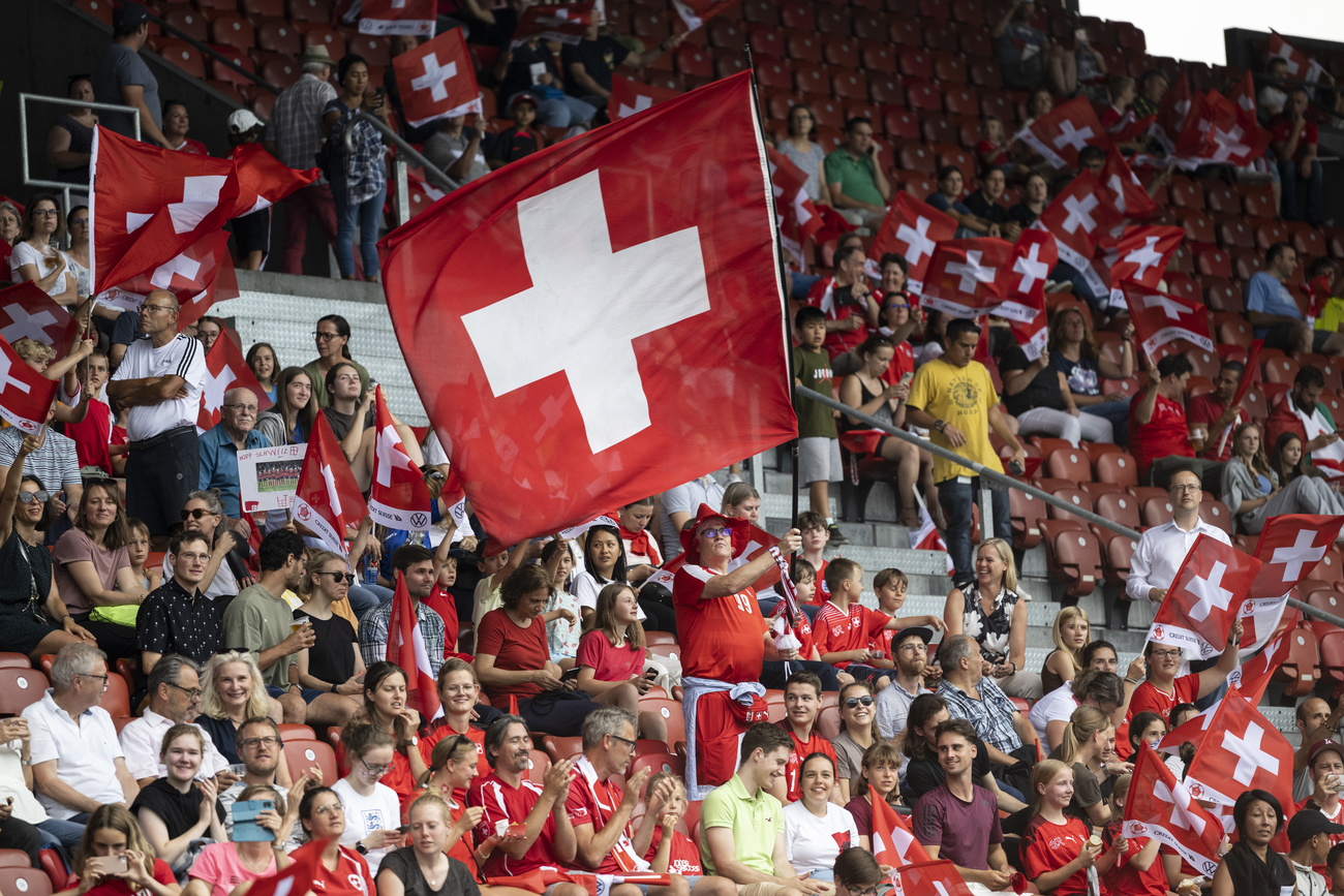 Público con banderas de Suiza en estadio de fútbol.