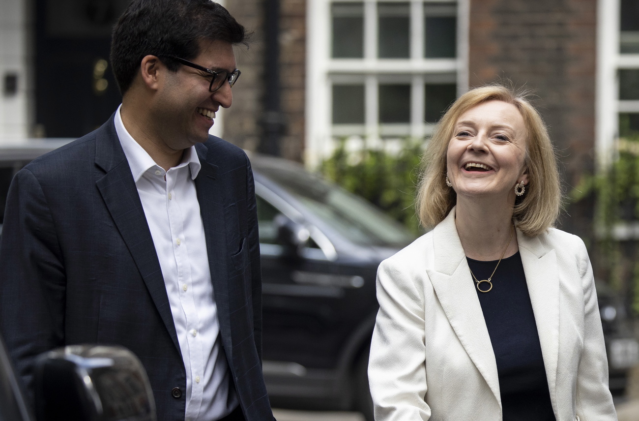 un uomo di origini indiane e una donna bionda ridono