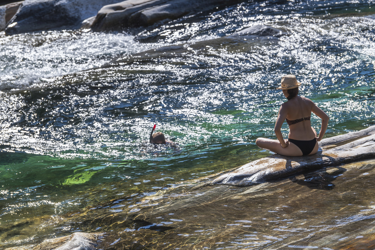 Una donna prende il sole in Valle Verzasca.