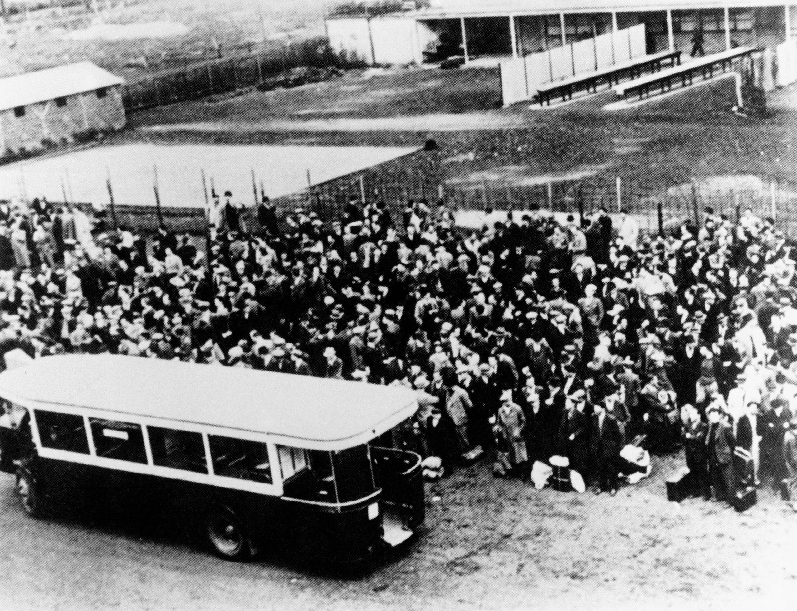 folla di gente accanto a un autobuis su una foto in bianco e nero