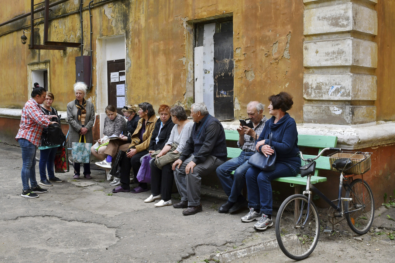 People wait to receive humanitarian aid in Ukraine.