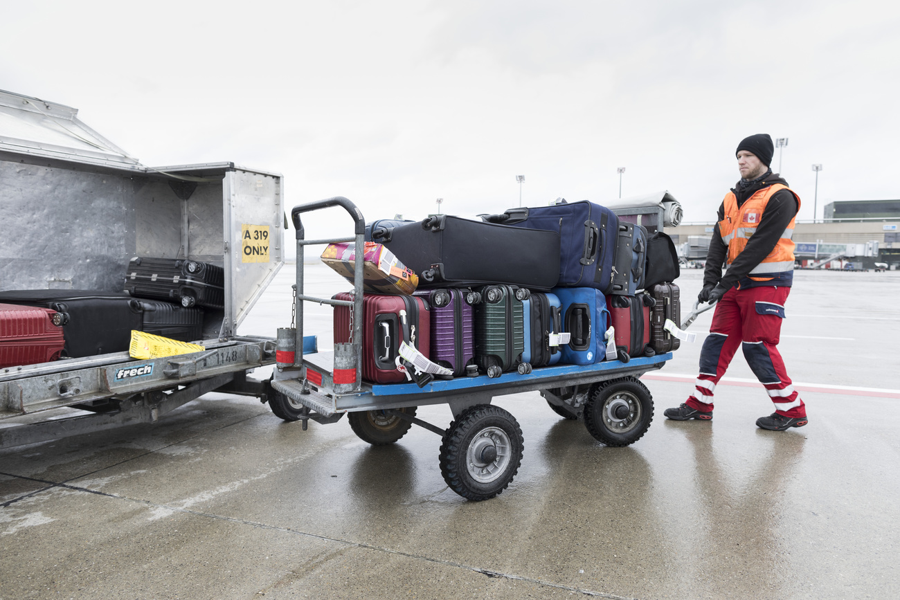 O bagageiro retira as malas da aeronave