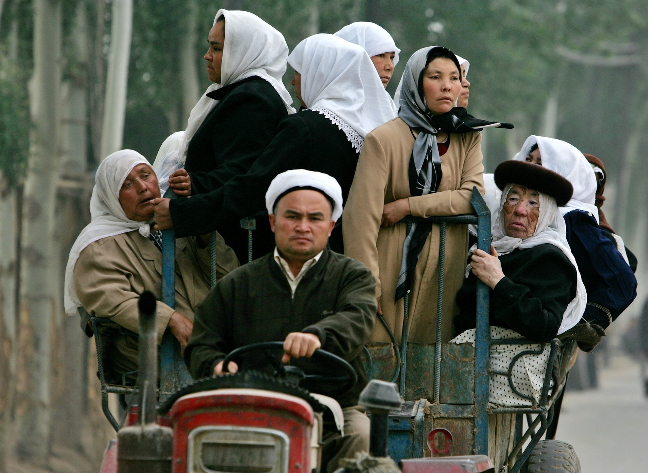 Mujeres musulmanas de la minoría uigur viajan en un tractor.