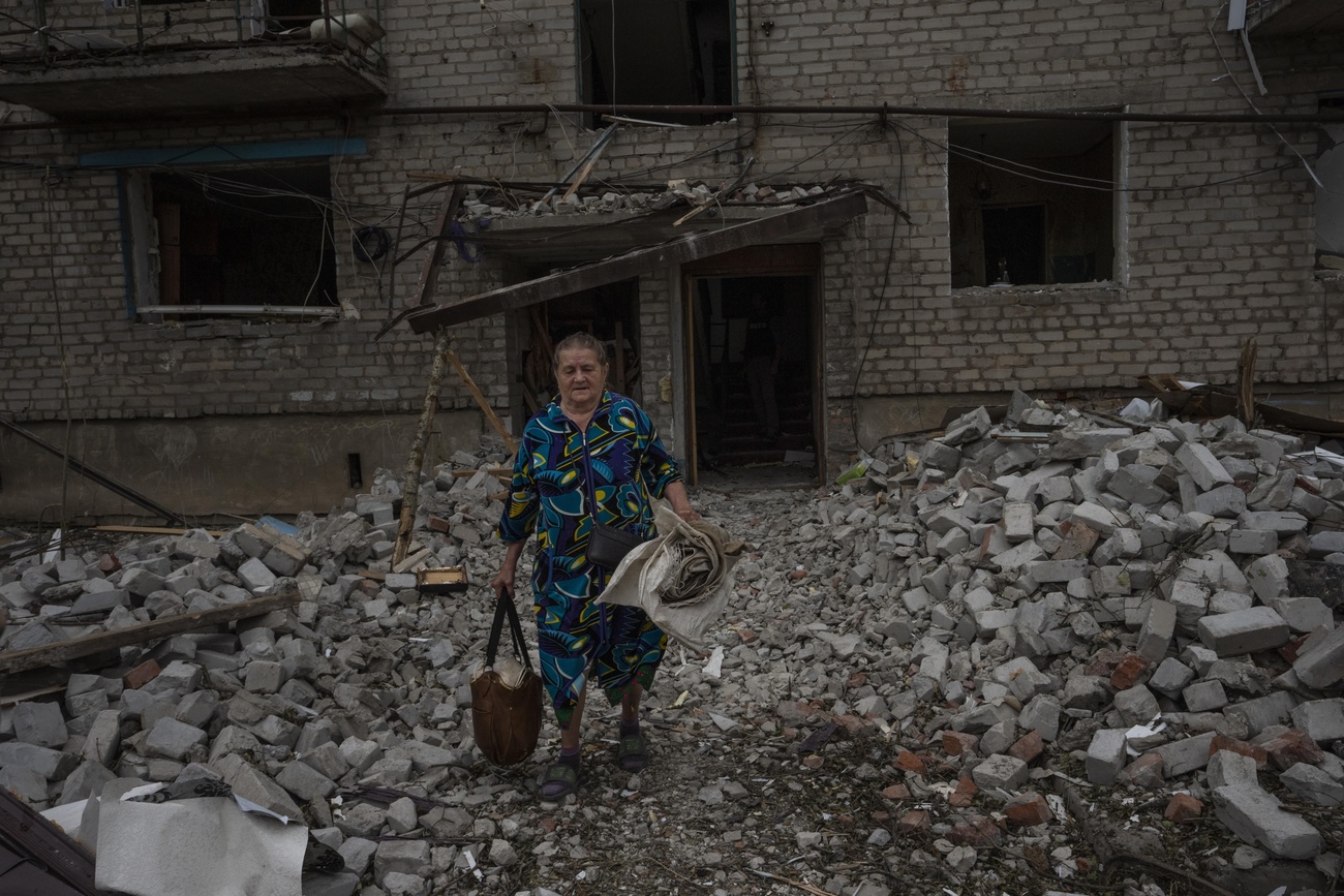 Mulher foge de prédio danificado na Ucrânia