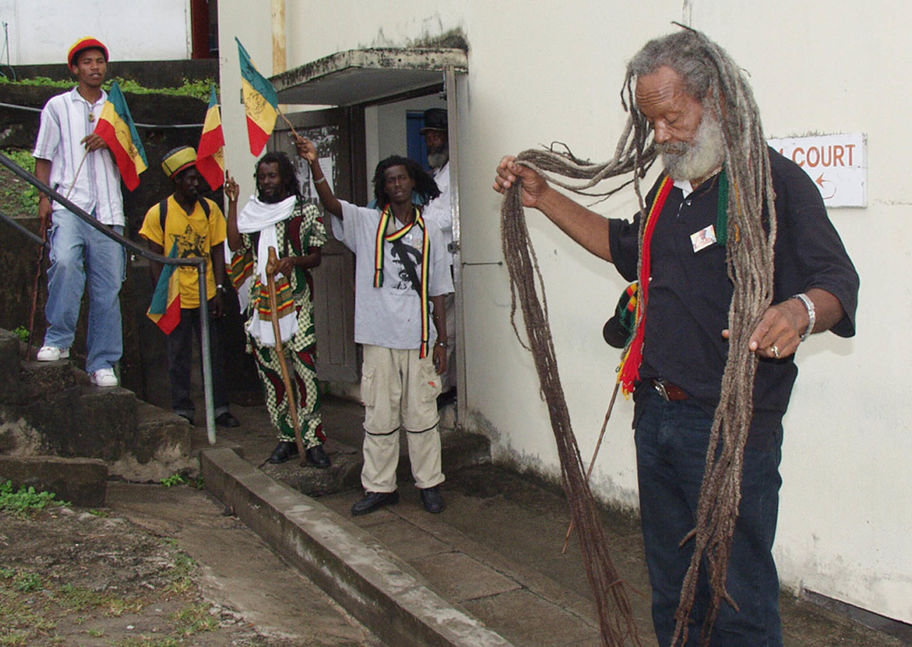 Varias personas. En primer plano, un hombre con largas rastas.