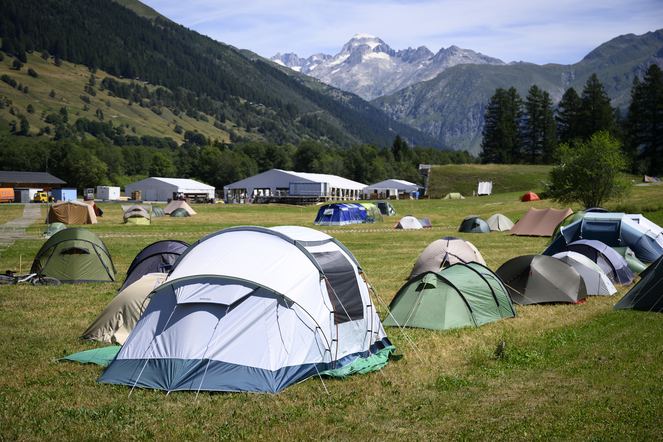 Tents on a meadow with a mountain backdrop