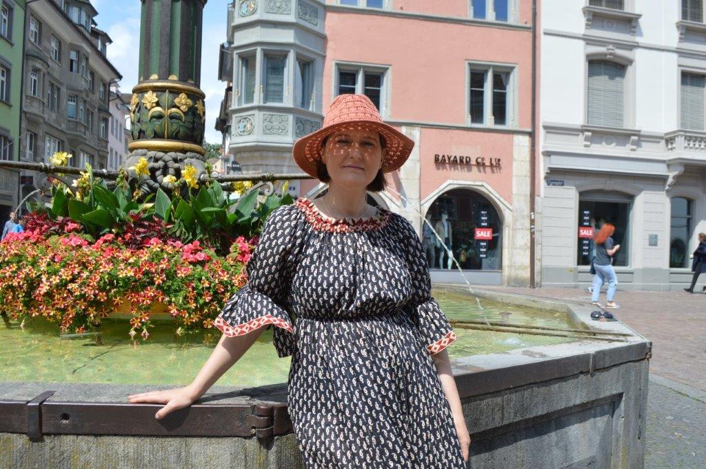 Femme à côté d une fontaine.