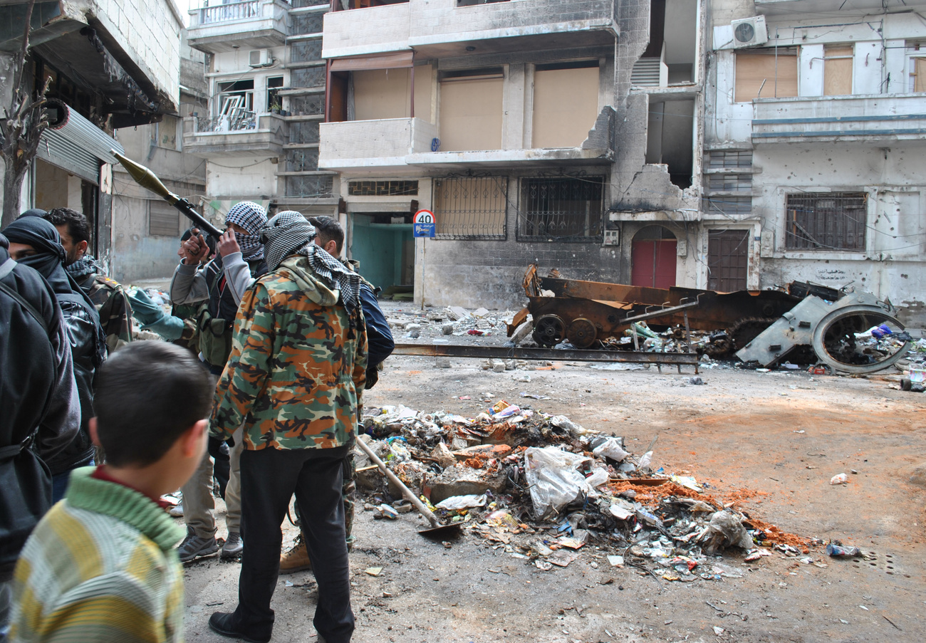 Syrian rebels by burned military vehicle