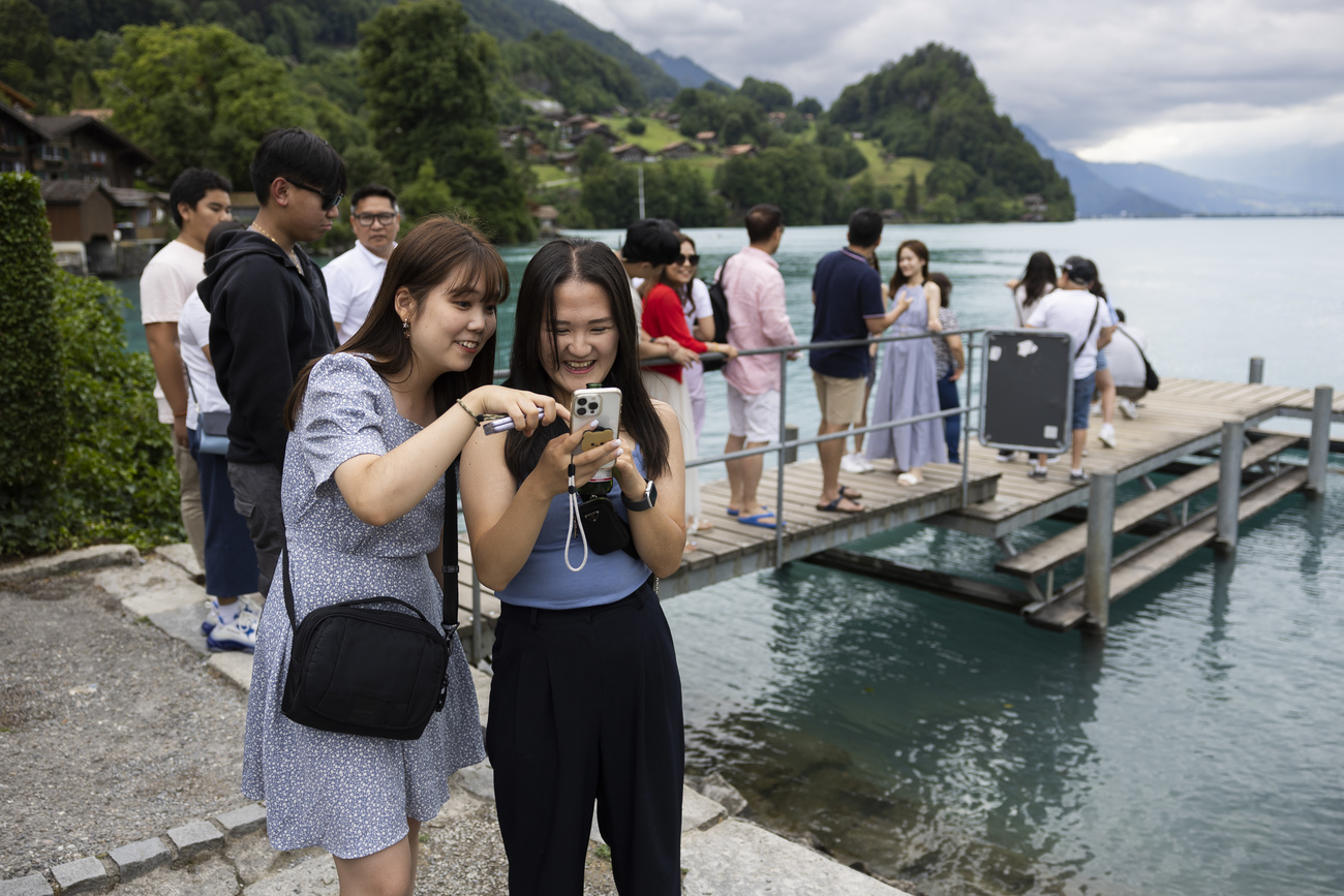 Asian tourists taking photos at the pier in Iseltwald.