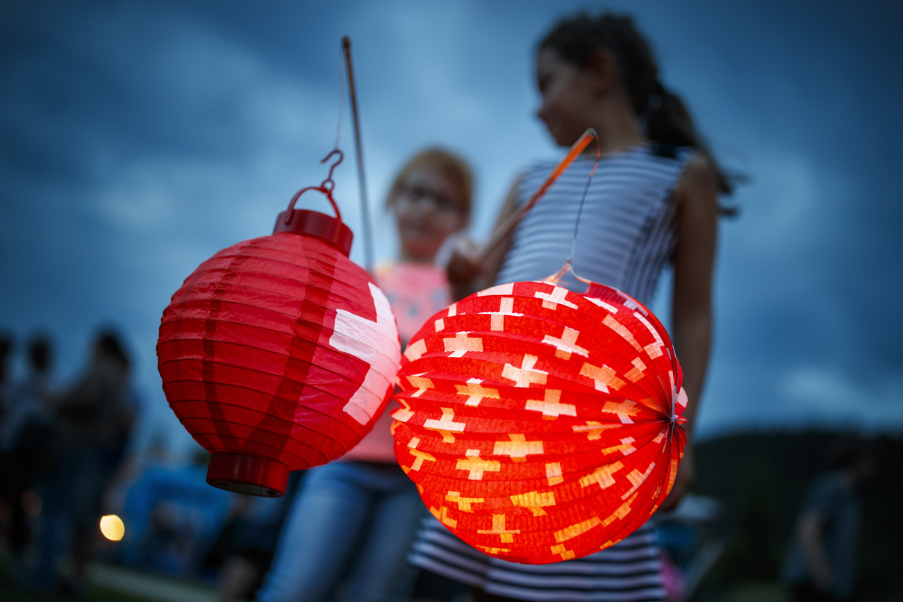 Una ragazzina con due lanterne con le bandiere della Svizzera