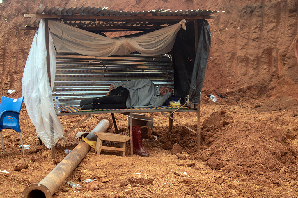 在昆苏的一个非法采矿点上，一名中国监理正在休息。