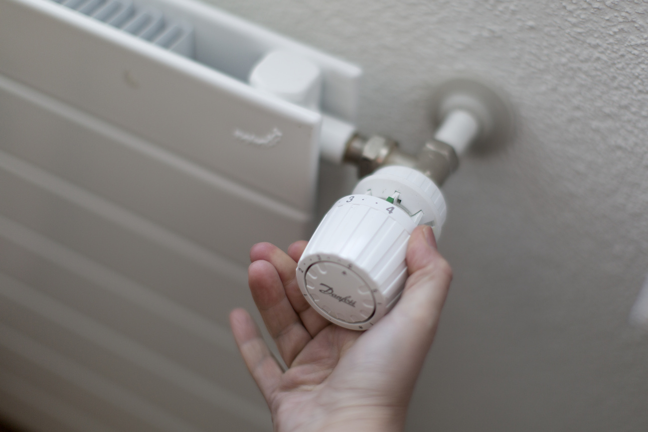 Person adjusts thermostat heating