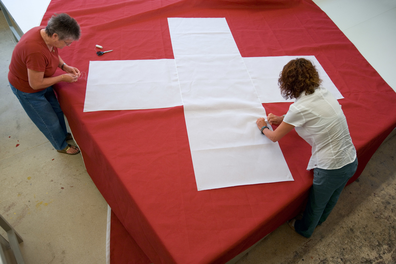 Zwei Frauen nähen an einer grossen Schweizerflagge