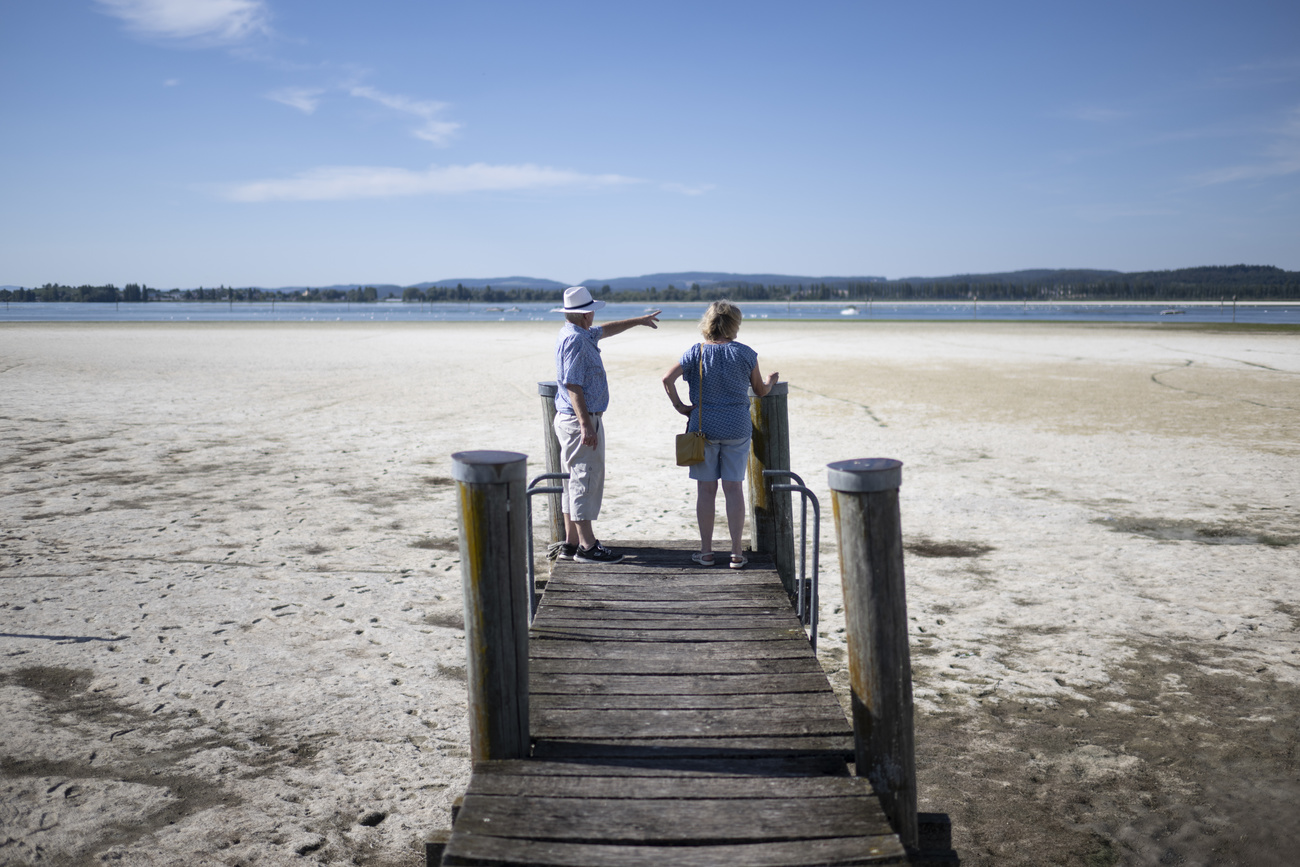 People on peer at low water level lake