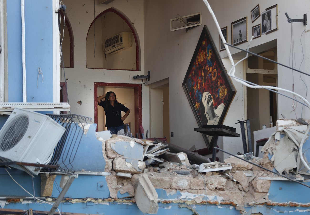 امرأة تتأمل الأضرار التي لحقت مطعما في بيروت