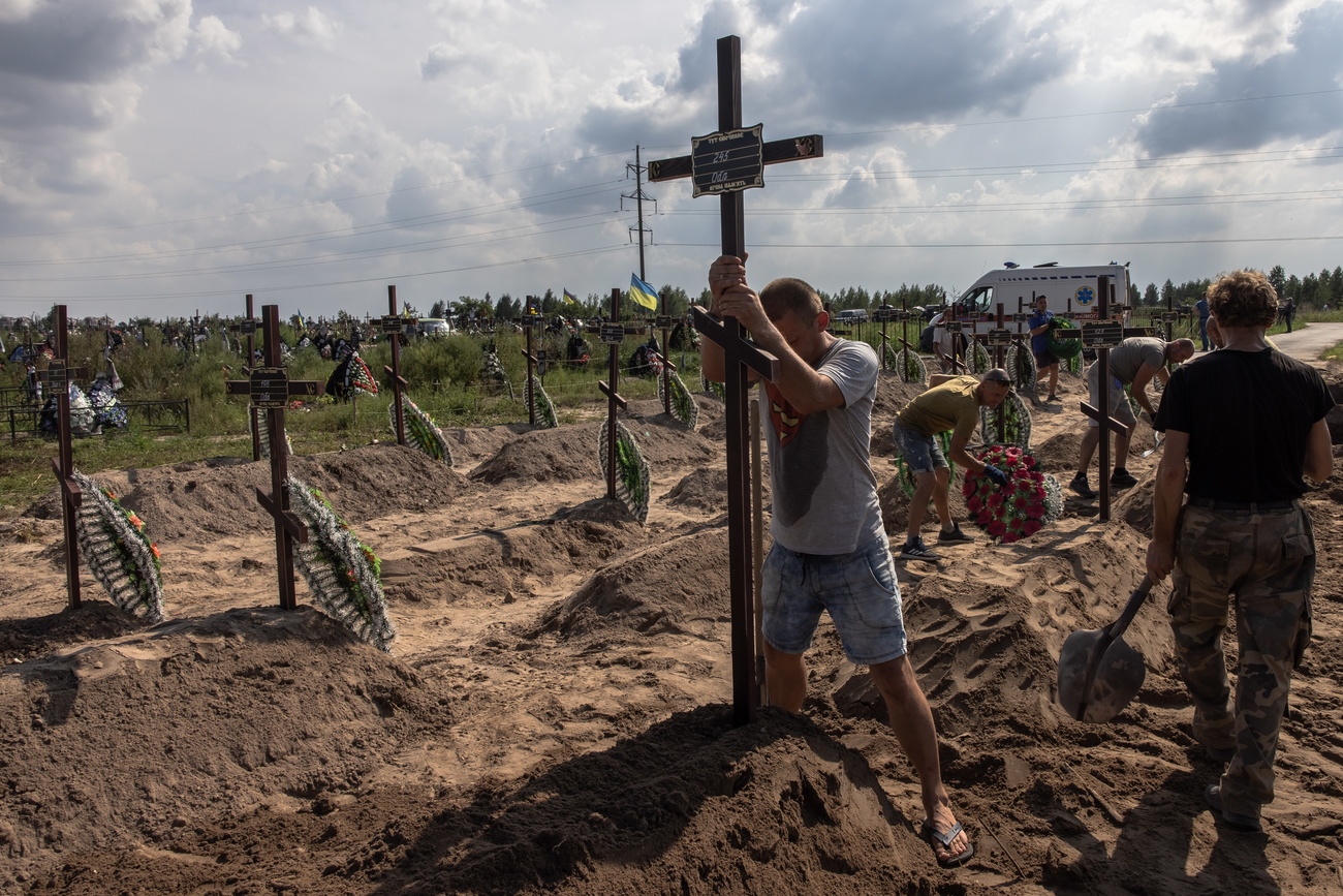 Люди устанавливают кресты на кладбище в Украине