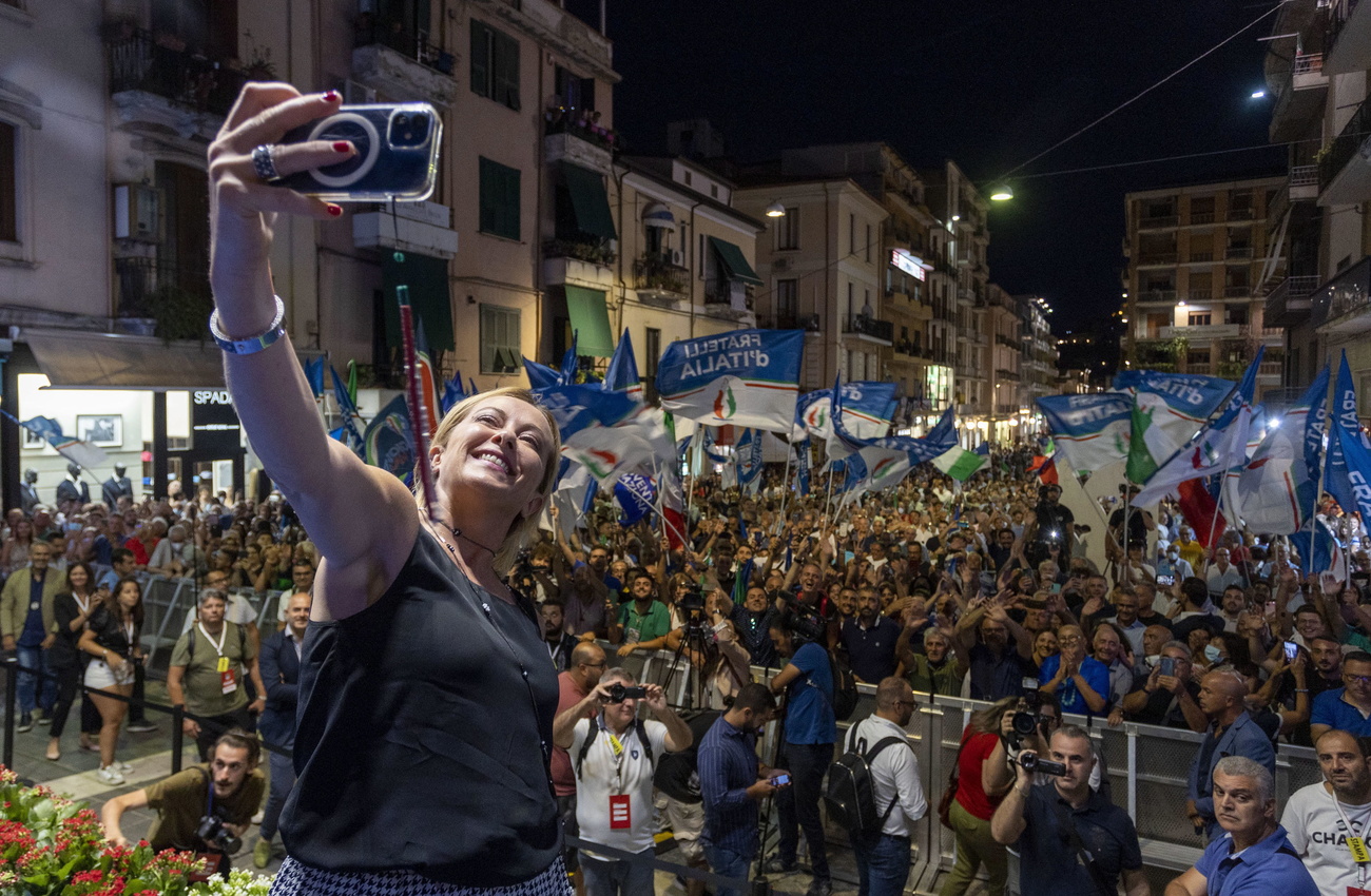 donna si fa un selfie con alle sue spalle una piazza gremita
