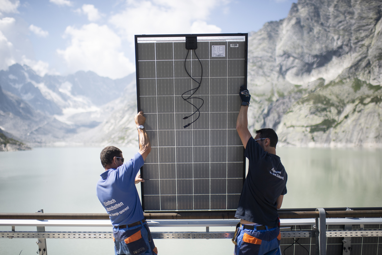 Solarzellen werden auf einer Staumauer in den Bergen montiert